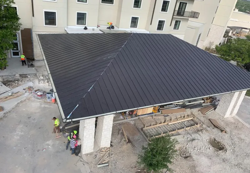 Metal roofing installation team working on a commercial building in Carterville